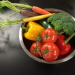 Verdure crude e cotte in un piatto, confronto sugli effetti del colesterolo nel sangue.